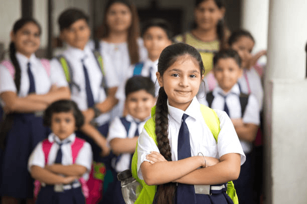 Smiling schoolgirl in uniform with classmates